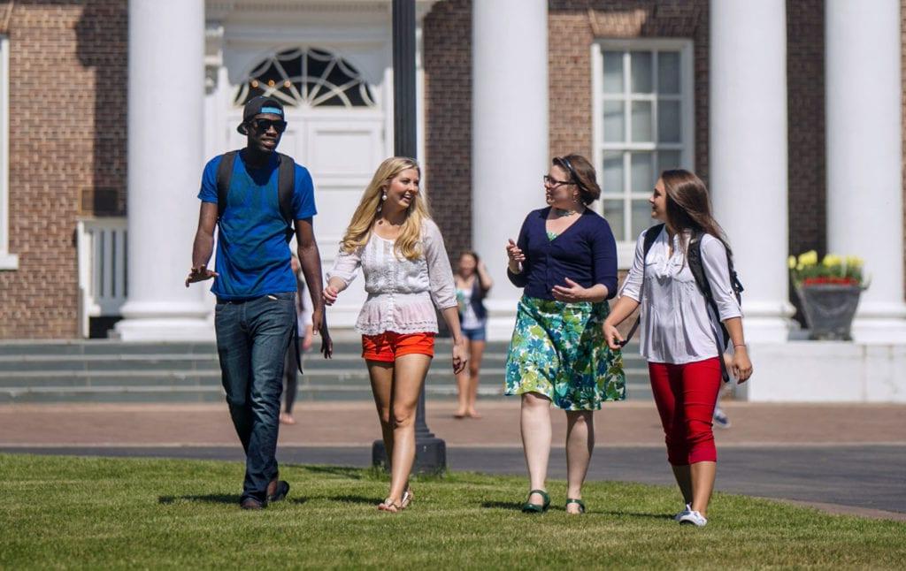 4 people walking on the lawn in front of Davidson Hall at 正规博彩十大网站